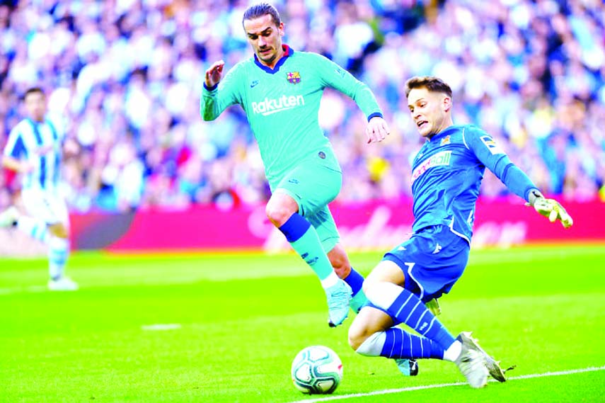 Barcelona's Antoine Griezmann (left) vies with Real Sociedad's goalkeeper Alejandro Remiro during their La Liga match at Anoeta stadium in San Sebastia on Saturday.