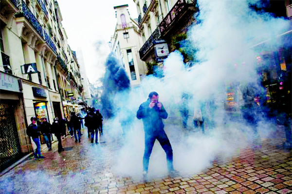 A man stands in tear gas as people take part in a demonstration in France.