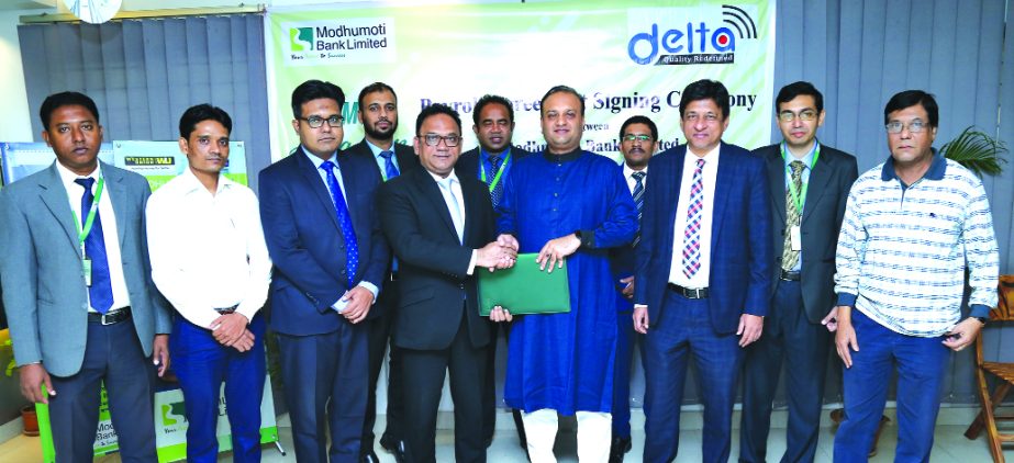 Md. Shaheen Howlader, Head of SME & Retail Banking Division of Modhumoti Bank Limited and Tanvir Shakil Joy, Chairman of Delta Software and Communication Limited, exchanging documents after signing an agreement at the bank's head office in the city recen