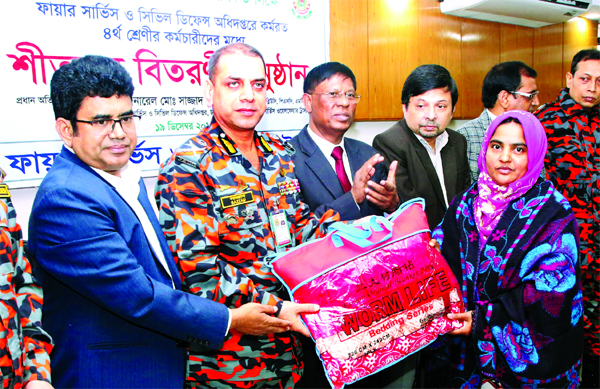 Director General of Fire Service and Civil Defence Department Brig Gen Sajjad Hossain distributing warm clothes among the class four employees of the department in its auditorium in the city on Thursday.