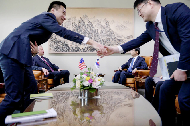 Aides shake hands as US special representative for North Korea Stephen Biegun (2nd L) attends a meeting with South Korea's special representative for Korean peninsula peace and security affairs Lee Do-hoon (2nd R) at the Foreign Ministry in Seoul, South