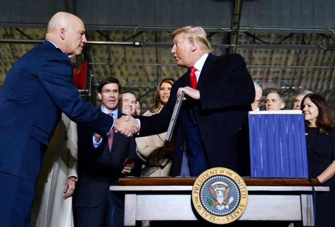 US President Donald Trump (right) shakes hands with Air Force General Jay Raymond, who will lead the newly established Space Force, at Joint Base Andrews, Maryland on Friday.