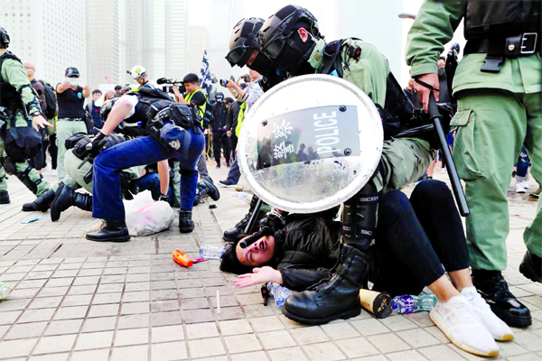 Police arrest a Hong Kong protester after a Chinese flag was removed from a flag pole at a rally in support of Xinjiang Uighurs' human rights, China, on Sunday.