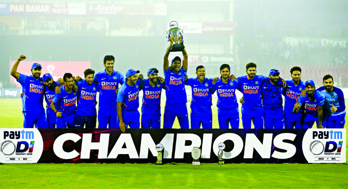 India's captain Virat Kohli (right) and teammates celebrate with the winners trophy after their win in the last One Day International cricket match against West Indies in Cuttack, India on Sunday. India won the series 2-1.