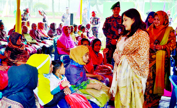 Wife of Director General of BGB Soma Islam distributing warm clothes among the destitute at a function organised by Simanta Paribar Kalyan Samity at the BGB training field in the city's Pilkhana on Monday.