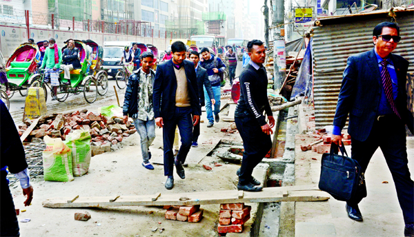 A busy road at Dainik Bangla intersection in the capital's Motijheel area is being dug to install sewerage line, causing immense sufferings to commuters and pedestrians. The photo was taken on Monday.