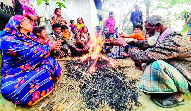 BHOLA: Poor people at Hasannagar Union in Bhola burning straws to warm themselves from cold yesterday.