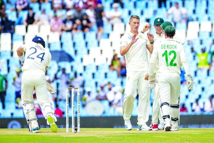 South Africa's bowler Dwaine Pretorius (center) celebrates with teammates after dismissing South Africa's bowler Dwaine Pretorius for 50 runs on day two of the first cricket Test match between South Africa and England at Centurion Park in Pretoria of So