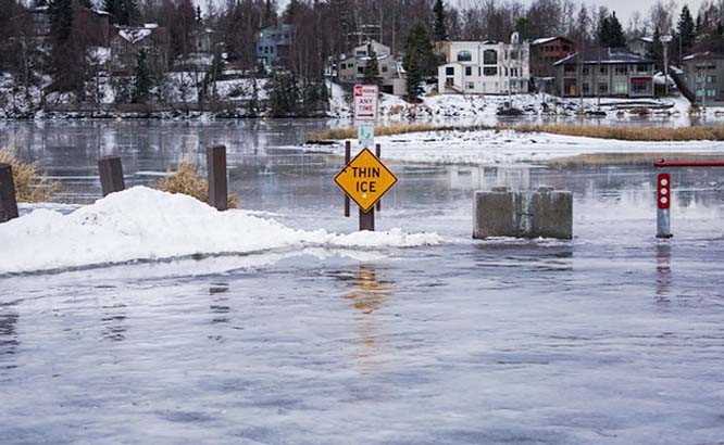 Winter rains atop of snow create a glaze on roads and parking lots and melt Westchester Lagoon in Alaska.