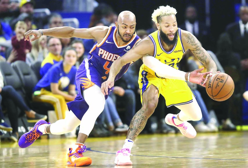 Phoenix Suns guard Jevon Carter (left) reaches for the ball while Golden State Warriors guard Ky Bowman defending during the second half of an NBA basketball game in San Francisco on Friday.