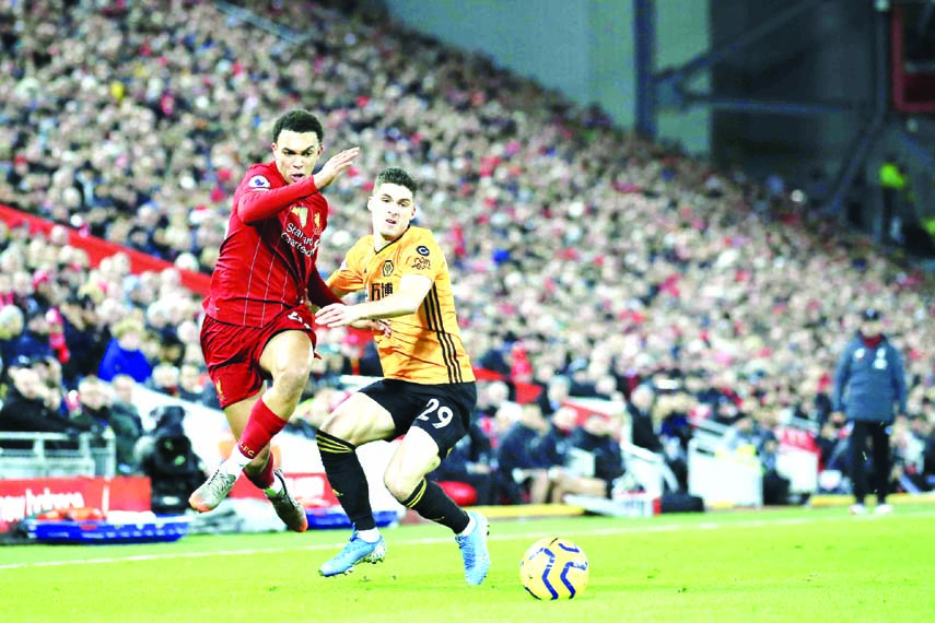 Liverpool's Trent Alexander-Arnold (left) fights for the ball with Wolverhampton Wanderers' Ruben Vinagre during the English Premier League soccer match between Liverpool and Wolverhampton Wanderers at Anfield Stadium in Liverpool of England on Sunday.