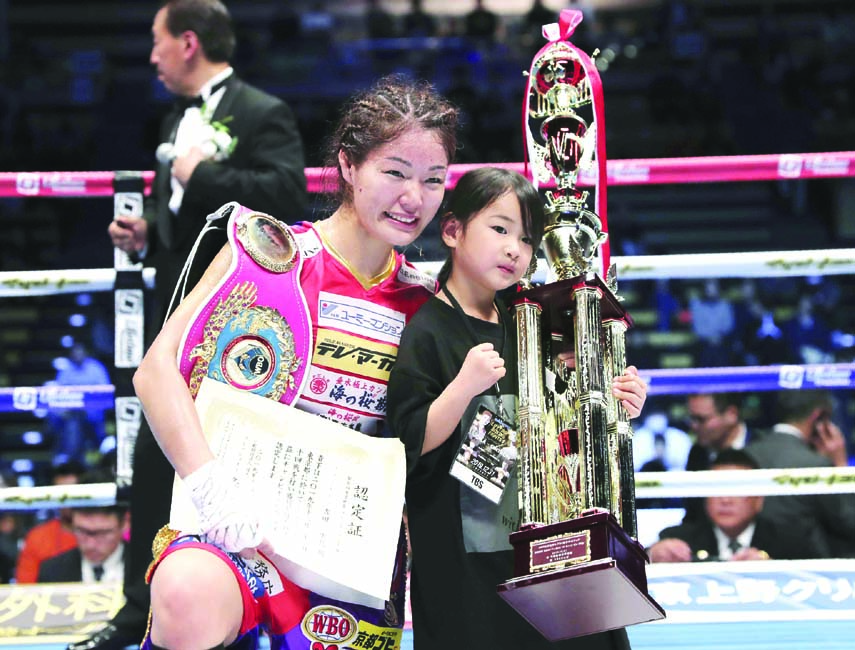 Japanese champion Miyo Yoshida poses with her daughter Mina Yoshida on the mat after her WBO women's super flyweight world boxing title match against Chinese challenger Shi Liping in Tokyo on Tuesday. Yoshida defended her title by