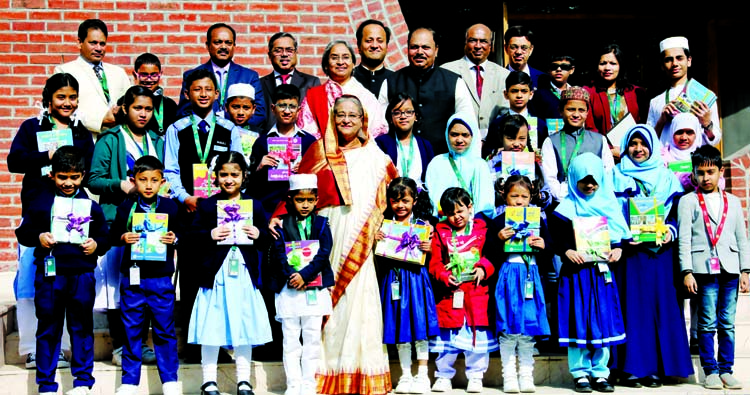 Prime Minister Sheikh Hasina poses for photo session with the children after handing over new books at the Ganobhaban on Tuesday. BSS photo