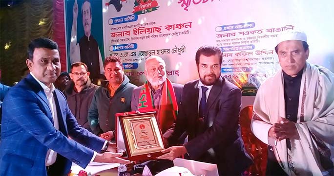 Panel Mayor Md. Zamiruddin Parvez handing over crest to the founder of' 'Nirapad Sarak Chai' and noted film personality Elias Kanchan at the reminiscence of Liberation War held at Bijoy Mela Mancha at Raozan on Sunday.