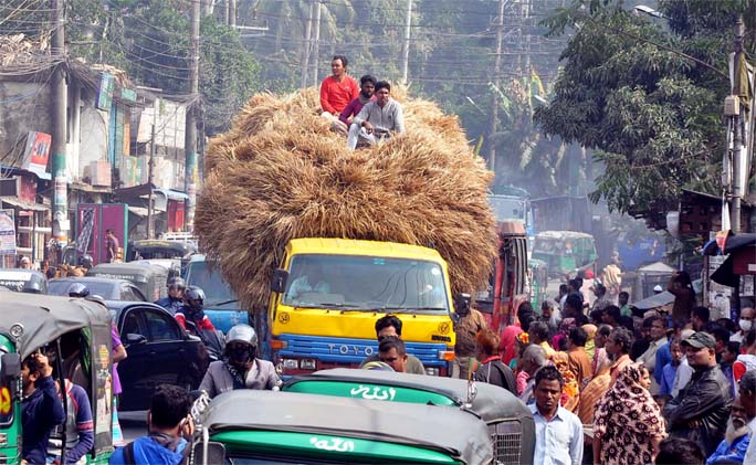 People, carrying straws to the Port City. This snap was taken from Akbarshah point yesterday. Photo: Bacchu Barua