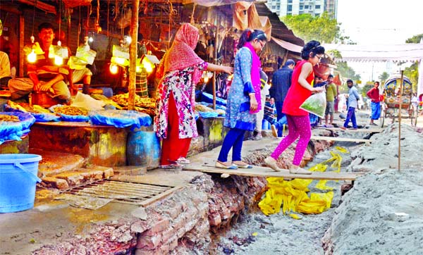 The residents of AGB Colony in the capital are facing immense sufferings as road excavations are going on for laying of utility lines. This photo was taken on Wednesday shows that a woman and her two daughters walk past through a wooden platform set up on