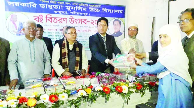 DAMUDYA (Shariatpur): Alamgir Hossain, Chairman, Damudya Upazila Parishad, Murtaza -Al- Moid, UNO distributing books among the students marking the National Textbooks Distribution Festival on Wednesday.