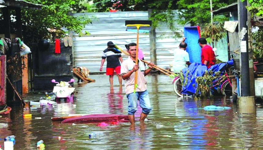 Men prepare to clean their flooded neighborhood in Tanggerang outside Jakarta, Indonesia, on Friday. Severe flooding in greater Jakarta has killed scores of people and displaced tens of thousands others, the country's disaster management agency said.