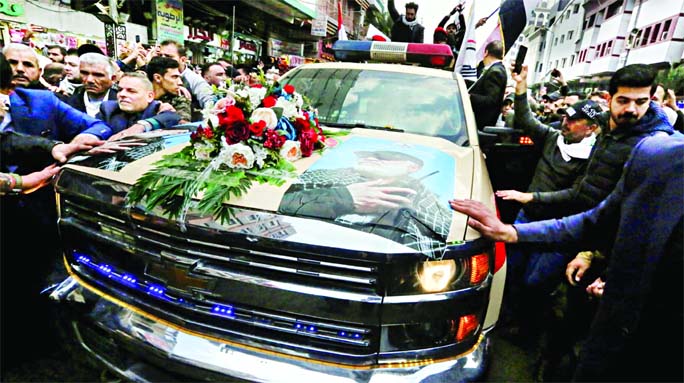 Mourners surround a car carrying the coffin of Iranian military commander Qasem Soleimani, killed alongside Iraqi paramilitary chief Abu Mahdi al-Muhandis in a US air strike, during a funeral procession in Kadhimiya, a Shiite pilgrimage district of Baghda