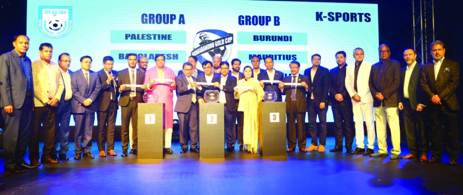 The participants of the draw ceremony showing the names of the teams, which will take part in the upcoming Bangabandhu Gold Cup International Football 2020, at the Ball Room in the Pan Pacific Sonargaon Hotel on Saturday.