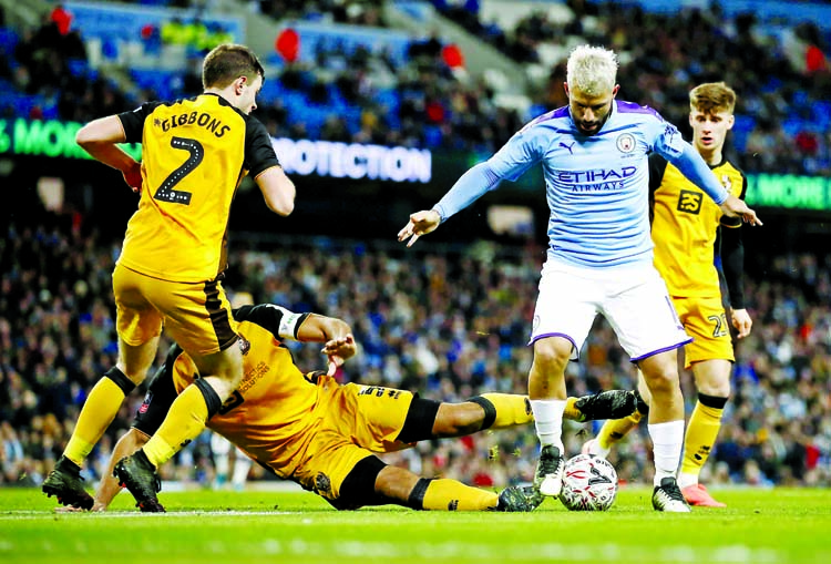 Manchester City's Sergio Aguero (right) battles for the ball with Port Vale's James Gibbons (left) and Leon Legge during the English FA Cup third round soccer match between Manchester City and Port Vale at the Etihad Stadium in Manchester of England on