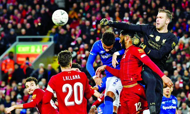 Liverpool's Spanish goalkeeper Adrian (right) punches the ball clear during the English FA Cup third round football match between Liverpool and Everton at Anfield in Liverpool, north west England on Sunday.