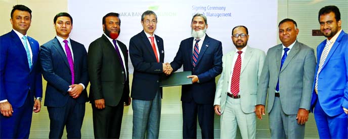 Emranul Huq, Managing Director (CC) of Dhaka Bank Limited and Md. Khalilur Rahman, Managing Director of National Housing Finance and Investments Limited (NHFIL), exchanging document after signing an agreement for providing online cash management services
