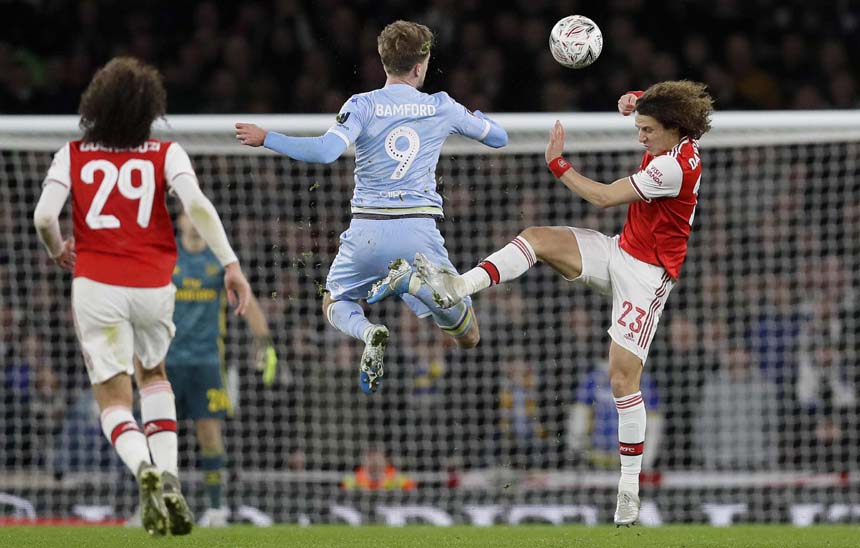 Leeds United's Patrick Bamford (center) and Arsenal's David Luiz (right) challenge for the ball during the English FA Cup soccer match between Arsenal and Leeds United at the Emirates Stadium in London on Monday.