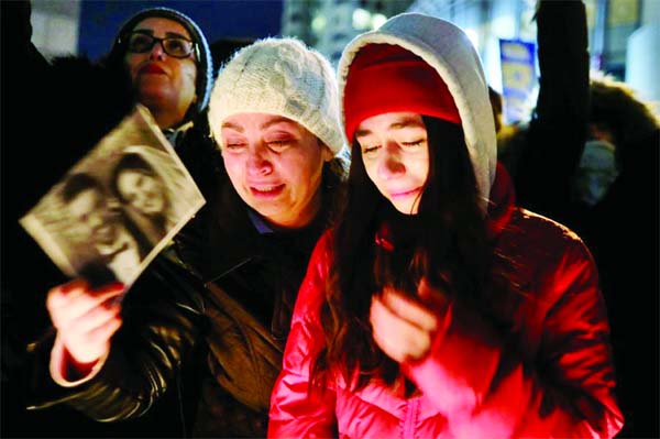 Mourners attend an outdoor vigil for the victims of a Ukrainian passenger jet which crashed in Iran, Toronto.