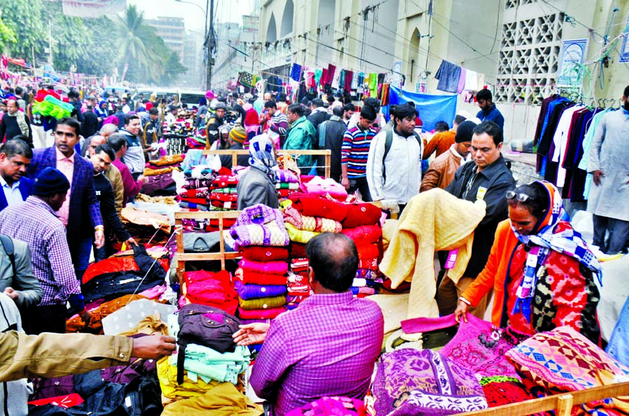 People throng makeshift shops in Baitul Mukarram area to buy warm clothes as mercury dipped across the country on Saturday.