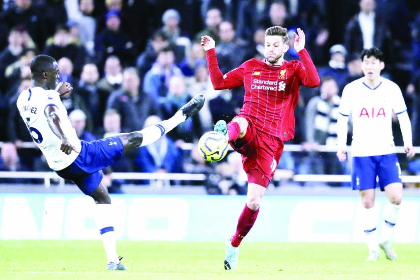 Tottenham's Davinson Sanchez (left) vies for the ball with Liverpool's Adam Lallana during the English Premier League soccer match between Tottenham Hotspur and Liverpool at the Tottenham Hotspur Stadium in London of England on Saturday.