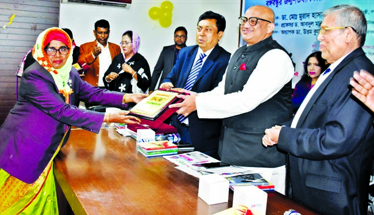 State Minister for Information Dr. Murad Hasan presenting citation crest to the Principal, College of Nursing Nasima Parvin for her contribution in nursing profession at a ceremony organised on the occasion of Bangabandhu's birth centenary by Amar Proka