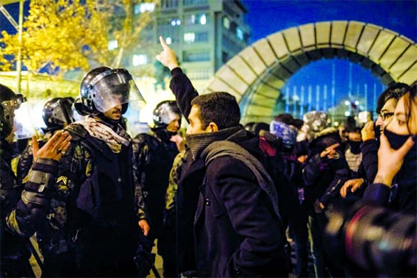 A man confronts riot police during a demonstration outside Tehran's Amir Kabir University after Iran admitted to having shot down a Ukrainian passenger jet by mistake.
