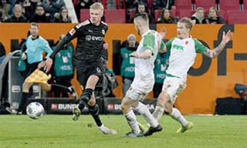 Dortmund's Erling Braut Haaland (left) scores against Augsburg during their German League match at Augsburg in the Bundesliga on Saturday.