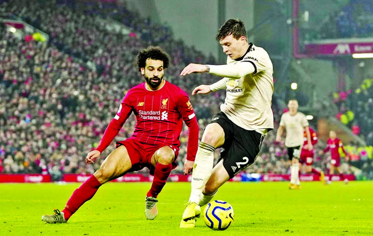 Liverpool's Mohamed Salah (left) and Manchester United's Victor Lindelof challenge for the ball during the English Premier League soccer match between Liverpool and Manchester United at Anfield Stadium in Liverpool on Sunday.