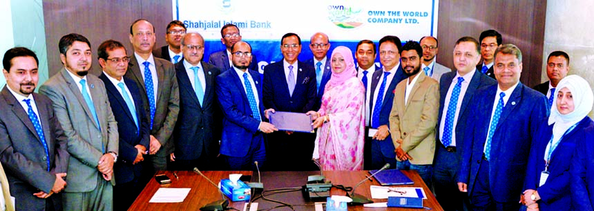 Md. Marufur Rahman Khan, head of card division of Shahjalal Islami Bank Limited and Tanzin Zaman, CEO of Own the World Company Limited, exchanging a MoU signing document at the bank's corporate head office in the city on Monday. Under the deal, all Credi