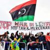 Protesters hold a banner reading "Stop war in Libya