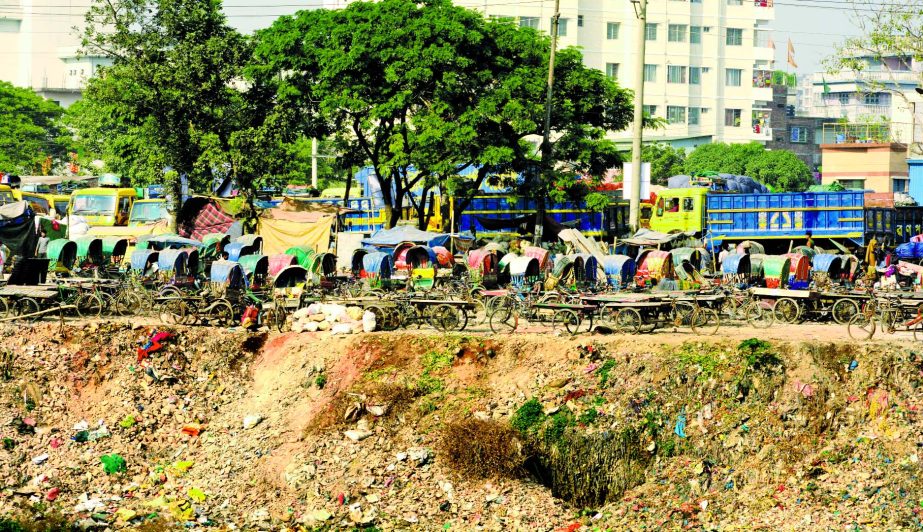 Grabbing, filling up and building establishments on the banks of river Buriganga continue despite eviction drives by concerned authorities. This photo was taken on Tuesday shows that an influential quarter set up an illegal rickshaw stand at Islambagh are
