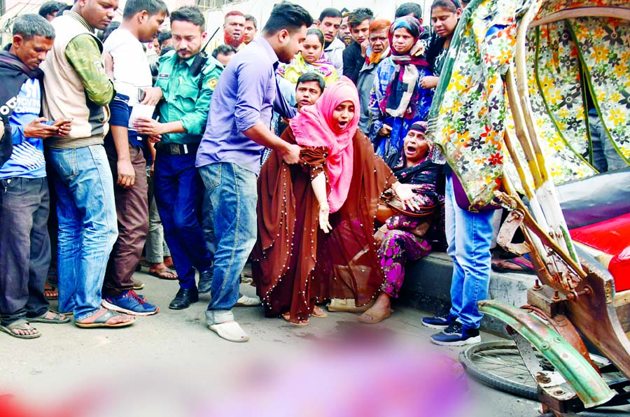 A girl was killed after a covered-van hit a rickshaw at Hatkhola Road in Dhaka on Thursday. Photo shows that relatives wailing as they mourn for the victim at the accident spot.