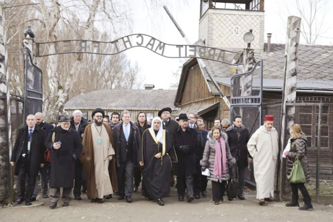 A delegation of Muslim religious leaders at the gate leading to the former Nazi German death camp of Auschwitz, together with a Jewish group in what organizers called "the most senior Islamic leadership delegation" to visit the former Nazi death camp, i