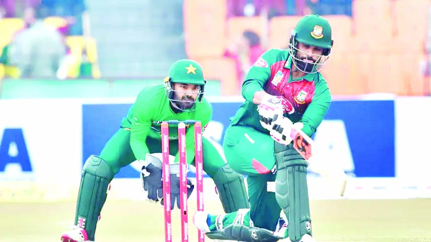 Bangladesh opener Tamim Iqbal bats, while Pakistani wicketkeeper Mohammad Rizwan looks on during the second T20I between Bangladesh and Pakistan at Gaddaafi Stadium in Lahore on Saturday.