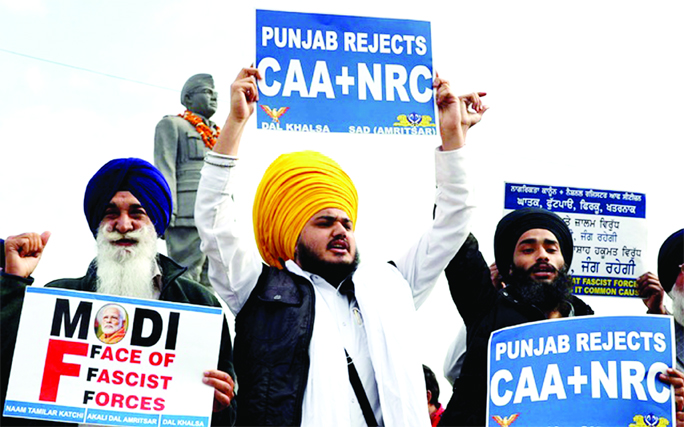 Demonstrator shout slogans as they display placards during a protest against a new citizenship law, in Amritsar, India on Saturday.