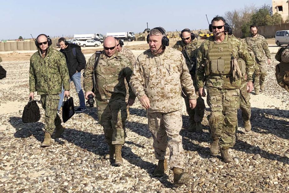 Gen. Frank McKenzie, center front, the top U.S. commander for the Middle East, walks as he visits a military outpost in Syria on Saturday.