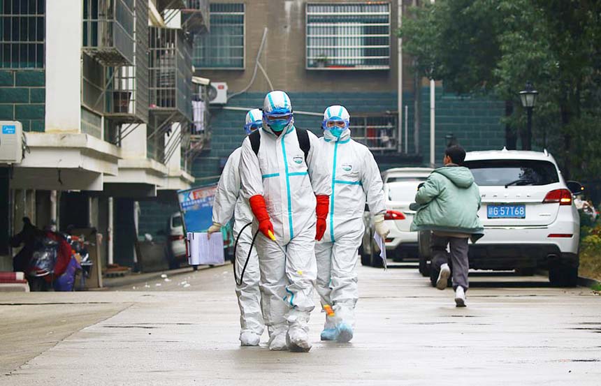 Workers from local disease control and prevention department in protective suits disinfect a residential area following the outbreak of a new coronavirus, in Ruichang, Jiangxi province.