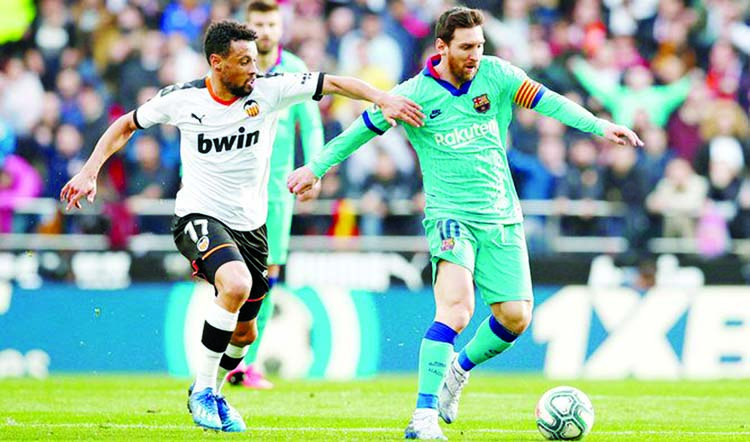 Barcelona's Lionel Messi (right) in action against Valencia's Francis Coquelin during their La Liga match in Valencia on Saturday.