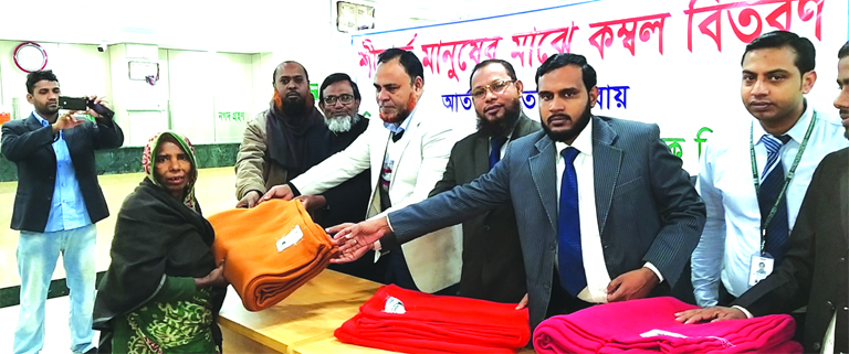 Mohammad Imram Hossain, Manager along with other officials of Rajbari branch of Al-Arafah Islami Bank Limited, distributing blanket among the cold affected people at the bank premises recently.