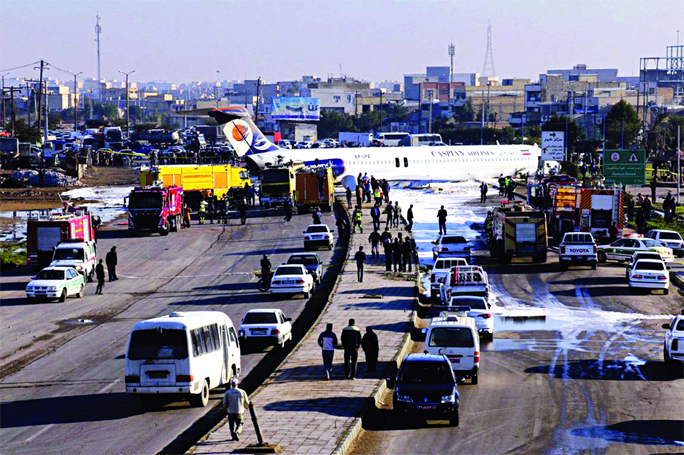 An Iranian passenger plane sits on a road outside Mahshahr airport after skidding off the runway, in southwestern city of Mahshahr, Iran on Monday.