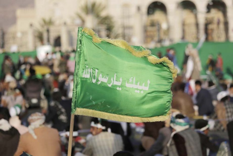 A supporter of Shiite rebels, known as Houthis, holds a banner with Arabic writing that reads, "at your order, Oh messenger of Allah," during a celebration of Mawlid al-Nabi, the birth of Islam's prophet Muhammad in Sanaa, Yemen.