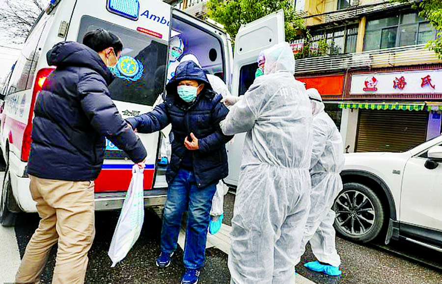 Fully protected medical staff help a patient off the ambulance outside the hospital in Wuhan Internet photo