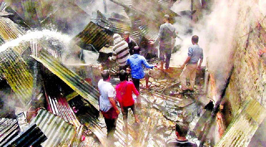 Firefighters and locals try to extinguish fire that broke out at a two-storey building in Moulvibazar, Sylhet on Tuesday.